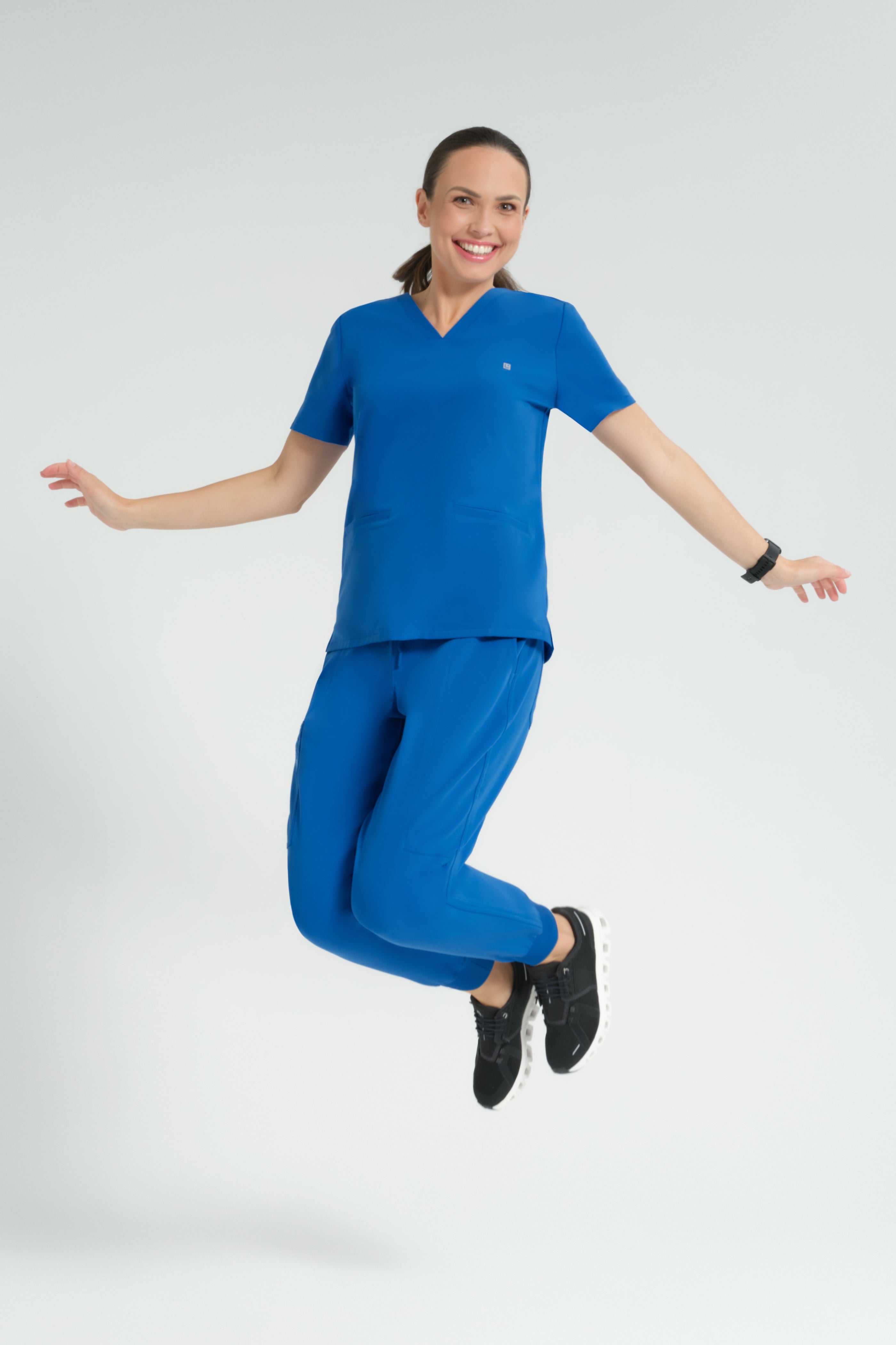 Woman wearing a blue scrub set on a white background